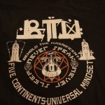 Black t-shirt with white screen printing featuring graphic text reading “BEHOLD THE MAGNIFICENT FIVE CONTINENTS-UNIVERSAL MINDSET,” alongside symbols, two figures, and geometric designs. Rain City West