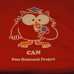 Red t-shirt featuring a cartoon owl in a graduation cap, screen printed with the text "CAN Peer Outreach Project" below the illustration—a fun design from Screen Printing Mania. Rain City West