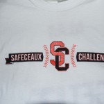 White t-shirt with "SAFECEAUX CHALLENGE" and a large red "SC" logo in the center, with baseball stitching details. Rain City West