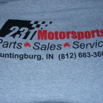 Gray T-shirt featuring "231 Motorsports Parts Sales Service" and contact info for Huntingburg, IN, printed in bold black and red by October Screen Printing. Rain City West