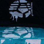 Three t-shirts in black, teal, and purple, each featuring a bold white graphic logo and the text "Rain City Soccer Club"—perfect for fans who want to show their support in style. Rain City West