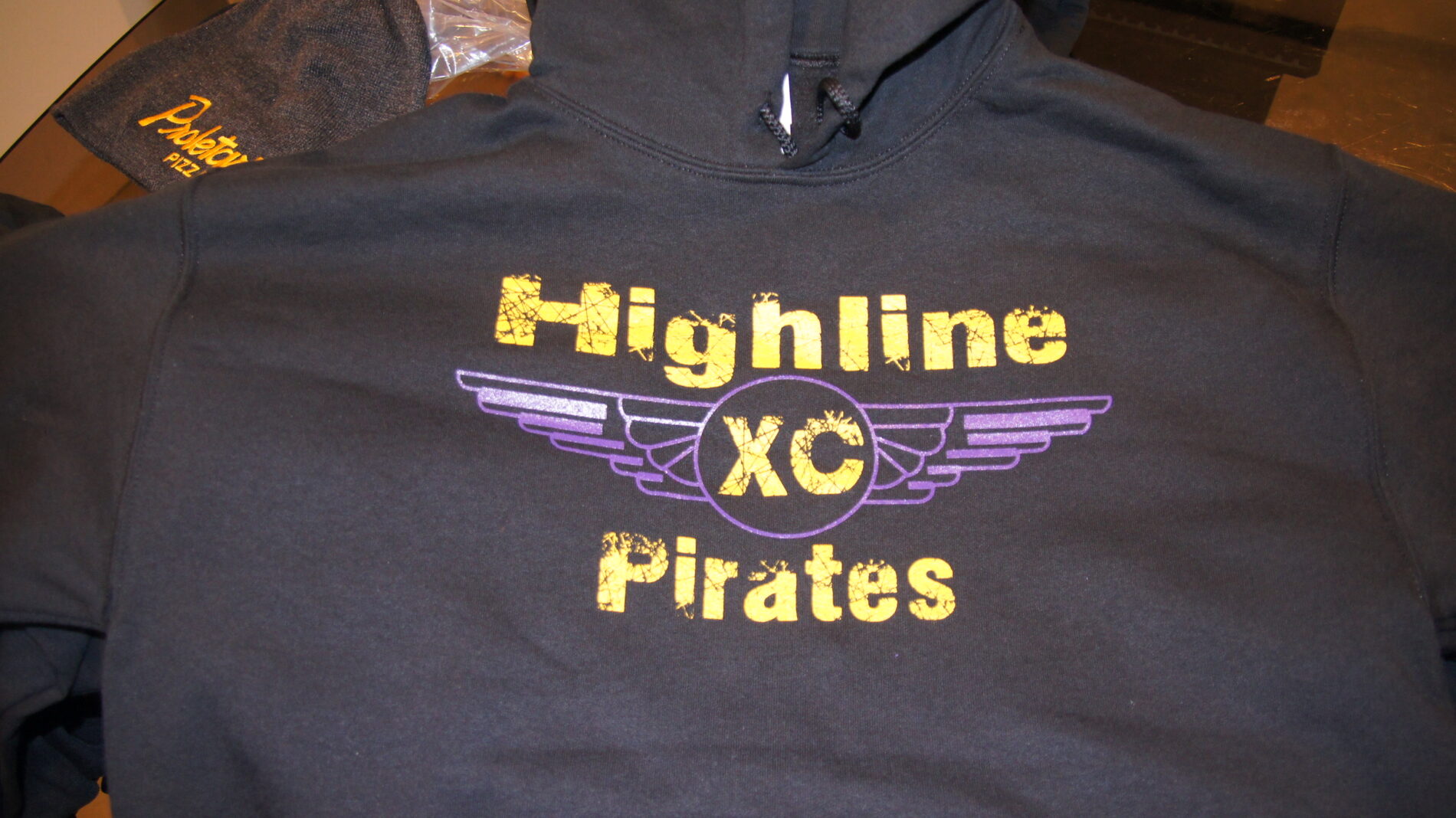 Black hoodies with Highline Pirates cross country image screen printed on the front.