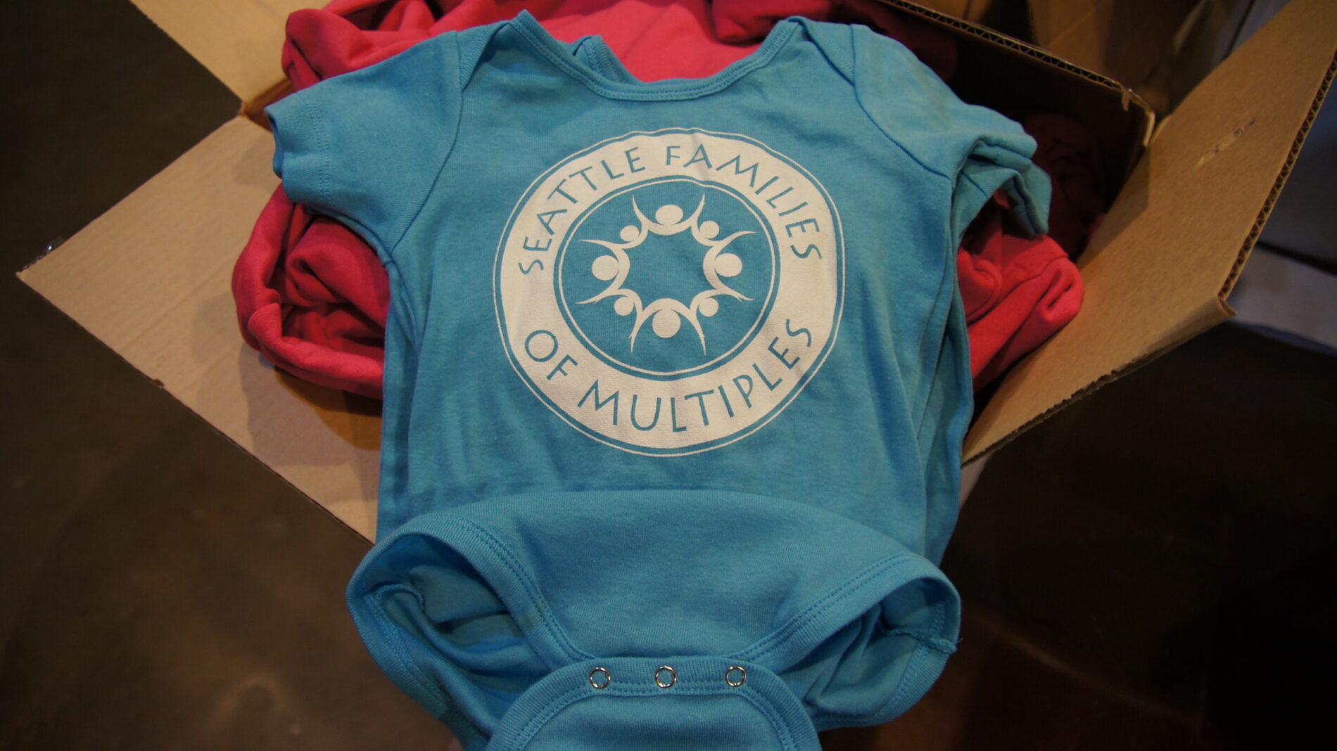 Screen printed onesie with the Seattle Family of Multiples logo.