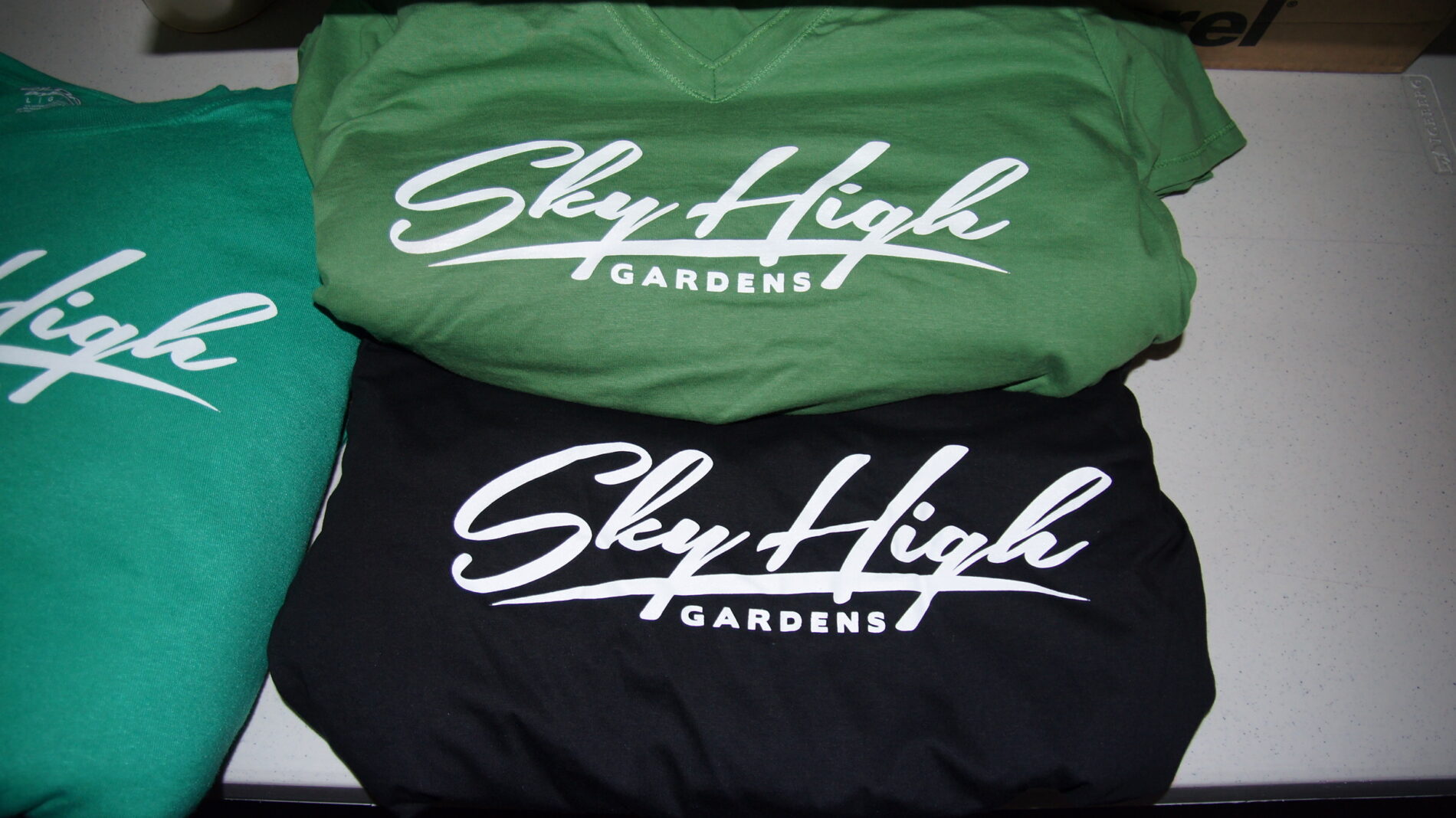 1-color screen print on multi-colored t-shirts for Sky High Gardens.