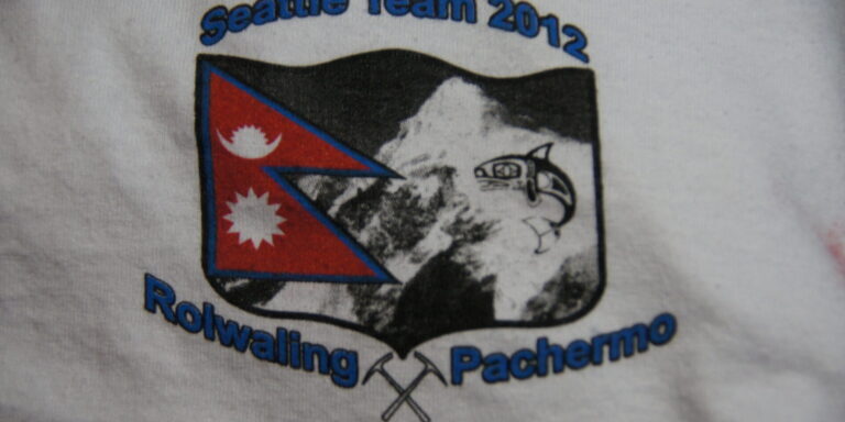 A t-shirt logo reads "Seattle Team 2012 Rolwaling Pachermo" with an image of Nepal's flag, a mountain, and a figure climbing—perfect for anyone cranking out shirts with an adventurous spirit. Rain City West