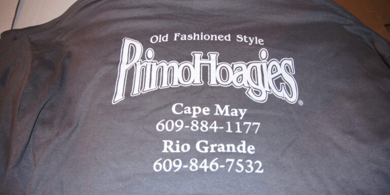Gray T-shirt with "Old Fashioned Style PrimoHoagies" and contact numbers for Cape May (609-884-1177) and Rio Grande (609-846-7532). Also available as sweatshirts for extra comfort. Rain City West